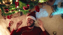 Boy enjoy the Christmas with headphone music under the tree