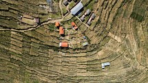 Aerial shot drone flies forward with camera facing down over farm on Isla del Sol in Lake Titicaca