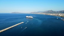 Aerial shot drone panning to right as cruise ship leaves port in Palermo, Sicily, Italy