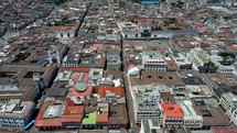 Aerial shot drone flies toward Plaza de San Francisco Javier with traffic and people walking around
