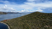 Aerial shot drone flies to left while facing east over Isla del Sol in Lake Titicaca