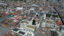 Aerial shot drone flies left while panning right around major tourist area in downtown Quito