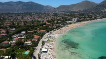 Aerial shot drone ascends over south side of Mondello Beach looking north in Palermo, Sicily, Italy