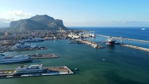 Aerial shot drone flies to right over cruise port in Palermo, Sicily, Italy with Mount Pellegrino in the distance
