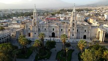 Aerial shot drone orbits to left in tight shot of Basilica Cathedral of Arequipa and Plaza de Armas