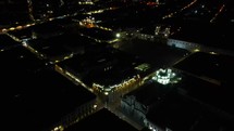 Aerial shot drone pans left in semicircle around popular church in Quito at night