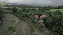 Aerial flying over tropical house in Asia Palm trees Village Town Ethnic