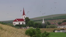 Romanian Countryside Landscape View Of Old Church And National Flag With Birds Flying