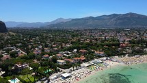 Aerial shot drone flies left while the camera pans right and down over south side of Mondello Beach in Palermo, Sicily, Italy