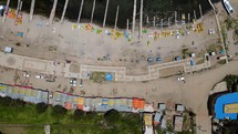 Aerial shot drone flies forward with camera facing down over long docks in boat marina before panning up over boats to see horizon