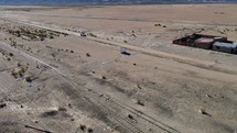 Aerial shot drone follows service vehicle as it enters desert town in middle of nowhere
