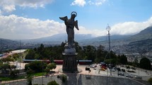 Aerial shot drone flies up and away from Panecillo, the virgin statue on the hill overlooking the city Quito