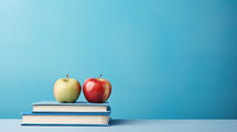 Apples on school books, blue background, text background