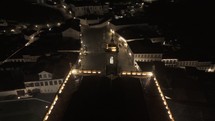 Drone flies to right behind bell tower in Museu da Inconfidência overlooking Praça Tiradentes in Ouro Preto, Brazil at night