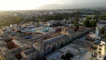 Aerial shot drone orbits in tight shot to left around Santa Catalina Monastery in Arequipa, Peru at dusk