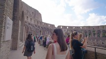 A beautiful woman tourist visiting inside the Coliseum. Happy moments of travel in ancient roman architecture in rome italy.
