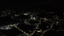 Drone flies over Ouro Preto at night toward Igreja de Nossa Senhora das Mercês e Perdões