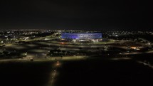 Drone flies forward toward Arena BRB Mane Garrincha at night in Brasilia, Brazil
