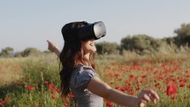 Young girl has fun with virtual reality in a field of red flowers