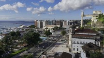 Drone flies past Lacerda Elevator and over Mercado Modelo in Salvador, Bahia, Brazil