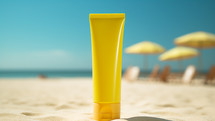 Yellow plastic Sunscreen lotion tube on sandy beach. 