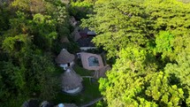 Aerial shot drone flies over resort hidden in the forest in the mountains.