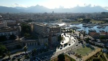 Aerial shot drone flies over Porta Felice at rush hour toward downtown Palermo, Sicily, Italy