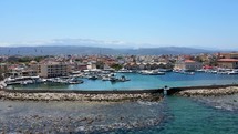 Aerial shot drone flies up and away from stone pier in port of Chania, Crete