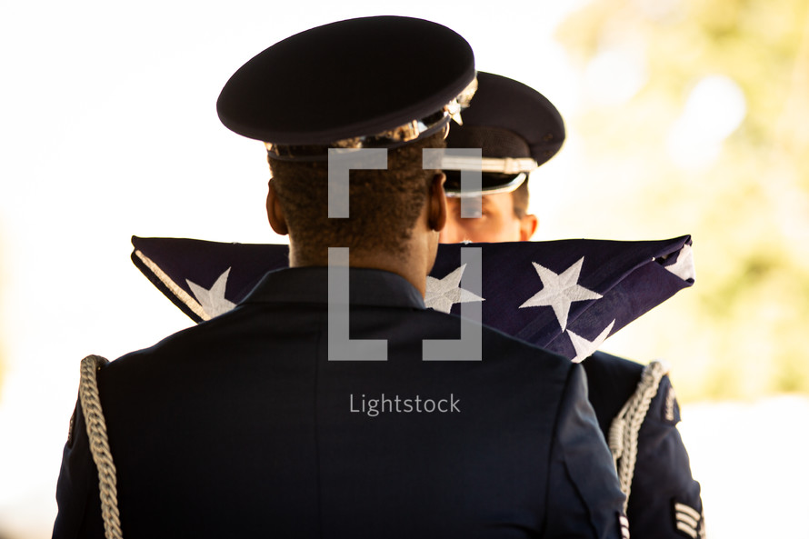 Soldiers stand at attention during flag presentation at veteran's graveside ceremony. "On behalf of the President of the United States, (the United States Army; the United States Marine Corps; the United States Navy; or the United States Air Force), and a grateful Nation, please accept this flag as a symbol of our appreciation for your loved one's honorable and faithful service."