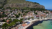 Aerial shot drone flies over north side of Mondello beach toward mountain in Palermo, Sicily, Italy