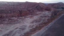 Aerial shot drone flies to the left in front of Death Valley facing sunset with San Pedro de Atacama behind the drone