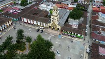 Aerial shot drone has dutch angle on church on main square as it lowers over park