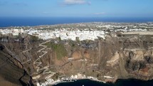 Aerial shot drone flies to right as camera pans left over the cable car in Thera, Santorini