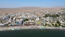 Aerial shot drone flies to the right with Paracas beach in the foreground and the desert in the background