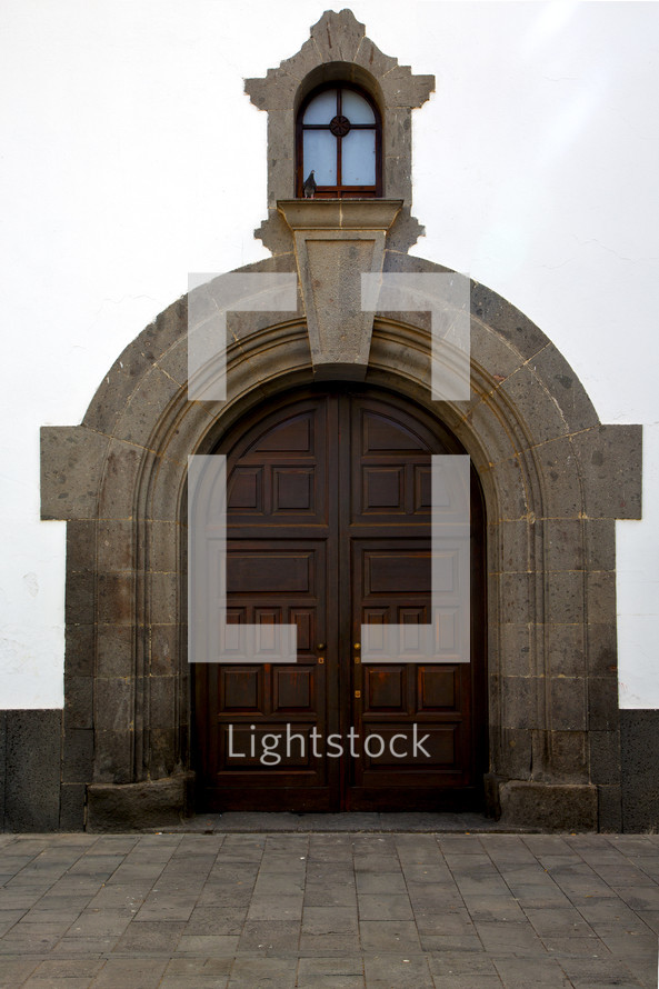 window over an arched door on a church 