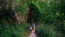 mother and son walking hand in hand on a nature trail 