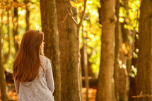 girl standing in a forest alone