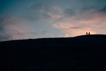 silhouette of a family on a hilltop 