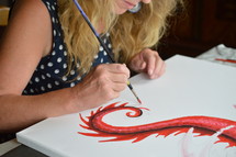 a woman painting on canvas 