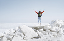 a girl jumping up outdoors in snow and ice 