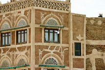 A white dove flying in front of a building in Yemen 