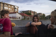 young people riding in the back of a truck in Eastern European looking town
