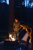 men standing near a campfire at night 