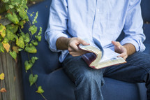 a man reading a Bible in his lap 