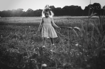 a little girl standing in a field 