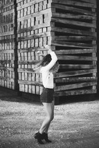 woman posing in front of stacked pallets