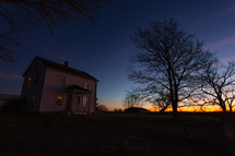 Farm house with tree at sunset