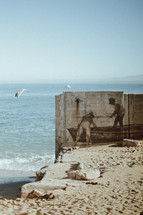 painting of fisherman on a concrete wall on a beach 