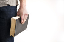 a man holding a Bible at his side 