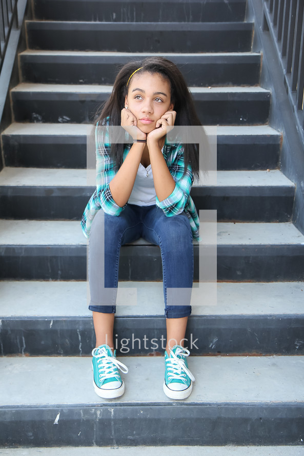 a teen girl sitting on steps 